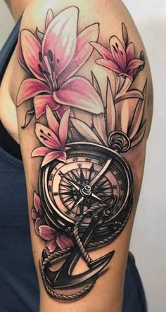 a woman's arm with flowers and an anchor on it