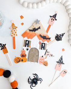 halloween decorations are arranged on a white surface, including popsicles and candy sticks