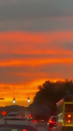 traffic is backed up at an intersection as the sun sets in the sky behind them