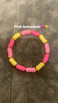 the pink lemonade bracelet is made with yellow and pink plastic beads on a gray background