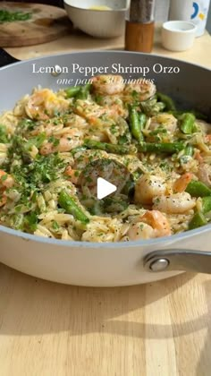 a pan filled with pasta and vegetables on top of a wooden table