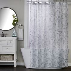 a white bath tub sitting under a bathroom mirror