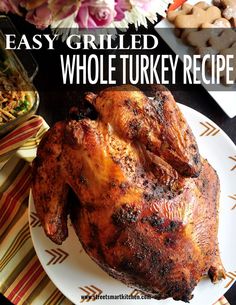 a whole turkey on a white plate with flowers in the background and text overlay that reads easy grilled whole turkey recipe