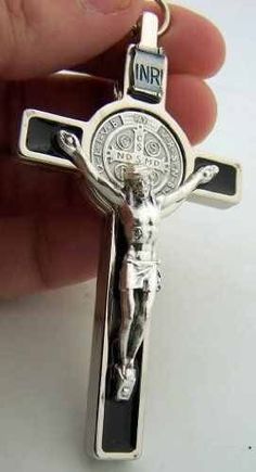 a person is holding a silver cross