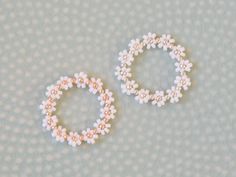 two white and pink beaded bracelets sitting next to each other