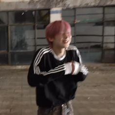 a young man with pink hair is playing frisbee