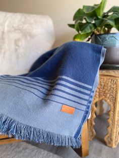 a blue towel sitting on top of a wooden table next to a potted plant