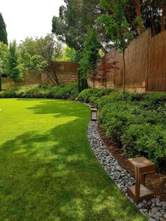 a garden with green grass and rocks in the middle