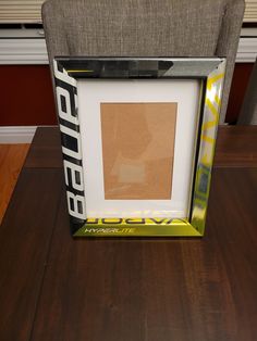 an empty photo frame sitting on top of a wooden table