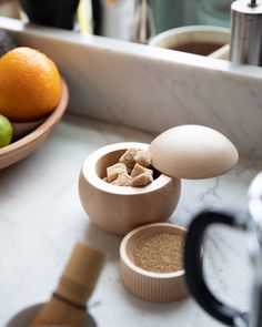 an assortment of food items sitting on a counter next to a bowl with fruit in it