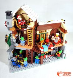 a lego house made out of legos and other toy items on a white surface