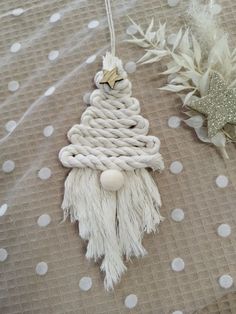 a white christmas tree ornament hanging from a string on a polka dot tablecloth