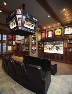 a room filled with lots of tvs and sports related items hanging from the ceiling