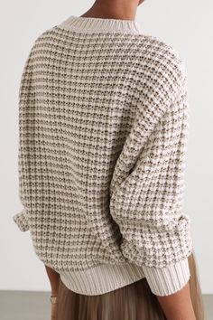 the back view of a woman wearing a white sweater