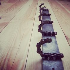 a row of metal chains sitting on top of a wooden floor