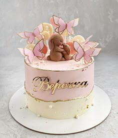 a pink and gold decorated cake with a teddy bear on top that says peppuccia