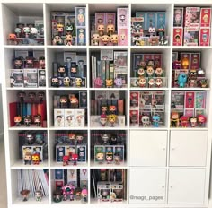 a white book shelf filled with lots of books and figurines on top of it