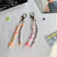 two key chains with letters and beads on them