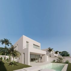 a white house with a pool in the foreground and palm trees on the other side