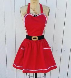 a mannequin wearing a red dress with white trims and a brown belt