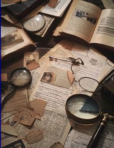 old books and magnifying glasses are scattered on top of an open book with torn pages