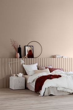 a bed sitting in a bedroom next to a wall with a mirror on top of it