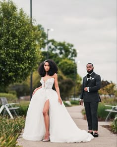 a woman in a wedding dress standing next to a man wearing a tuxedo