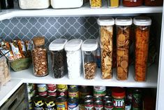 an organized pantry filled with canned food and condiments, including cookies, cereals, nuts, and other snacks