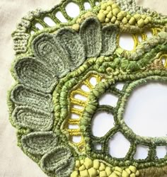 there are four pieces of green and yellow crocheted doily