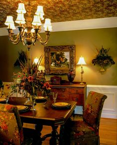 a dining room table with two chairs and a chandelier