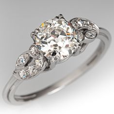 an antique style diamond ring with three stones on the side and two diamonds in the middle