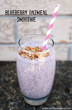 blueberry oatmeal smoothie in a glass with a pink and white striped straw