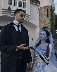 a man and woman dressed up as corpse brides in front of a building with a clock tower