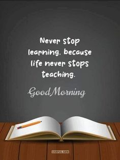 an open book sitting on top of a wooden table next to a blackboard with the words never stop learning, because life never stops teaching good morning