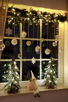 christmas decorations are hanging on the window sill