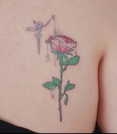 a woman's back with a flower tattoo on her left side and a fairy tinkerbell attached to it