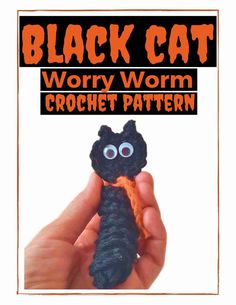 a hand holding a black cat crochet pattern with the words, worry worm crochet pattern