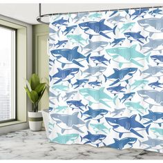 a shower curtain with blue and white sharks on it in front of a bathroom window