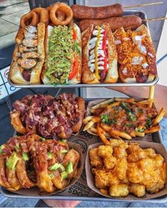 two trays filled with different types of food on top of each other, including hot dogs and tater tots