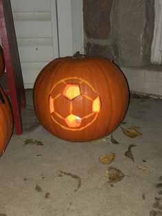 two carved pumpkins sitting on the ground next to each other