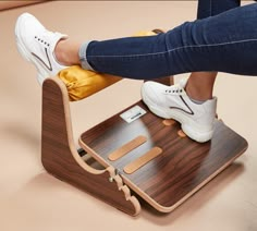 a person is standing on top of a wooden chair with their feet on the stool