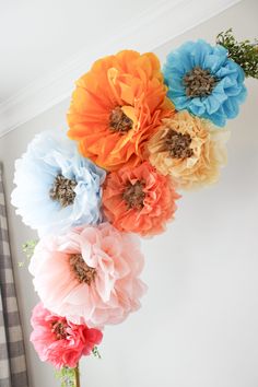 colorful paper flowers are hanging from the ceiling