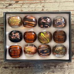 twelve glass marbles in a box on a wooden table