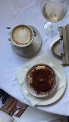 there is a cup of coffee on the table next to two plates with desserts