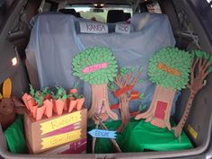 the trunk of a car is decorated with trees, carrots and other items that are for sale