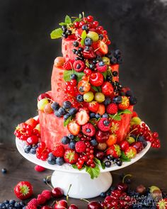 a watermelon cake with berries and strawberries on top