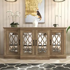 a large wooden cabinet with glass doors in a living room next to a painting on the wall