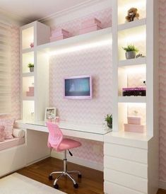 a pink chair sits in front of a desk with a tv on it and shelves