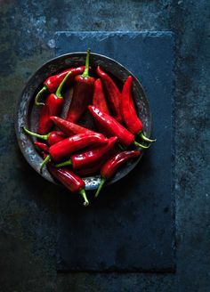 a bowl filled with red peppers on top of a table