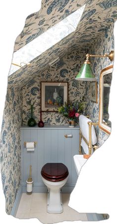 a bathroom with blue and white wallpaper has a toilet in the corner next to it